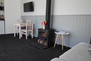 a living room with a stove and a table and chairs at Brecon Pond Bed & Breakfast in Stratford