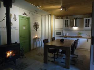 a kitchen and dining room with a table and a fireplace at KiOui in Rennes-les-Bains