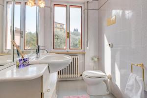 a white bathroom with a sink and a toilet at My Malcesine Family Home XL in Malcesine +40 photos