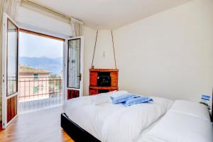 a bedroom with a fireplace and a bed with white sheets at My Malcesine Family Home XL in Malcesine