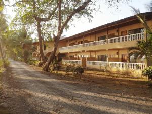 a building with a dirt road in front of it at Hotel Delfin Playa Bejuco in Esterillos Este