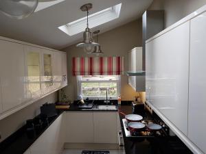 a kitchen with a stove and a window in it at Slough Centre Townhouse with driveway parking for up to two cars in Slough