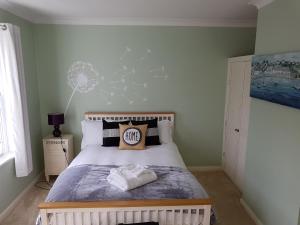 a bedroom with a bed with a white bed frame at Slough Centre Townhouse with driveway parking for up to two cars in Slough