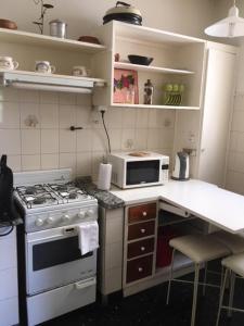 a small kitchen with a stove and a microwave at Mendoza Centrico Departamento Amoblado in Mendoza