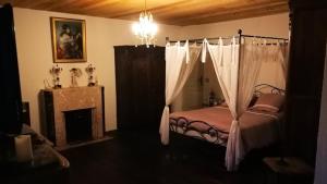 - une chambre avec un lit à baldaquin et une cheminée dans l'établissement Domaine de cyrcé, à La Celle