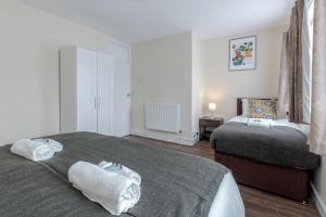 a bedroom with two beds with towels at Alphalite Homes in Barking
