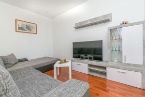 een woonkamer met een bank en een flatscreen-tv bij Apartment Ivano in Dugi Rat
