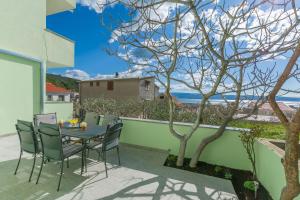 a patio with a table and chairs and a tree at Apartment Ivano in Dugi Rat