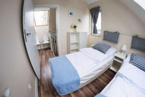 a small bedroom with two beds and a mirror at Piaskowa Polana in Dębki