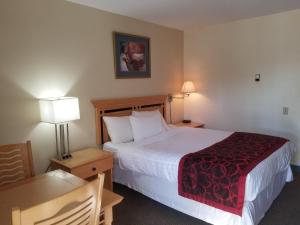 Rúm í herbergi á Canada's Best Value Desert Inn & Suites