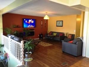 een woonkamer met een bank en een tv aan de muur bij Gracies Fallsview Getaway in Niagara Falls