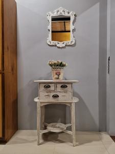 a console table with a mirror on a wall at Michel'inn Coron in Coron