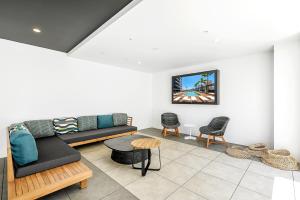 ゴールドコーストにあるQube Broadbeach Ocean View Apartmentsのソファと椅子のあるリビングルーム