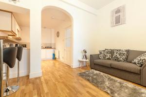 a living room with a couch and a kitchen at Beautiful Central Exeter Apartment 5 min walk quay in Exeter
