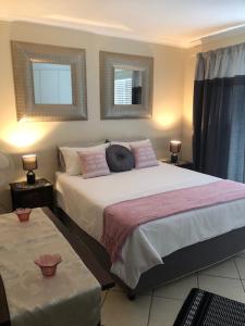 a bedroom with a large bed and two windows at Innikol 26 in Mossel Bay