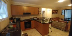a kitchen with a counter top and a living room at Innikol 26 in Mossel Bay