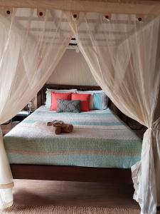 Una cama con dosel con zapatos. en Dubbo Rhino Lodge en Dubbo