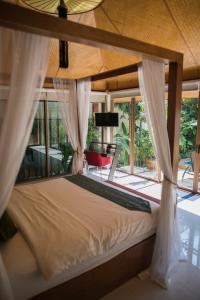 a bedroom with a bed with curtains and a patio at Pratumnak Soi 5 Bungalow 3 in Pattaya South