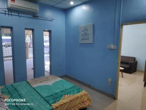 a room with a bed and a blue wall at Cempaka Homestay Batu Pahat in Batu Pahat