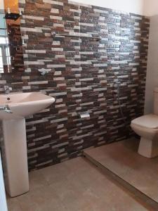 a bathroom with a sink and a brick wall at King's Lodge in Nuwara Eliya