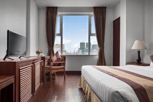 Cette chambre comprend un lit et une grande fenêtre. dans l'établissement Phnom Penh Katari Hotel, à Phnom Penh