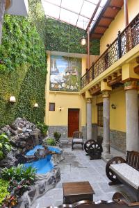 a patio with a pond and a stairway and a building at Hotel La Basílica Quito in Quito