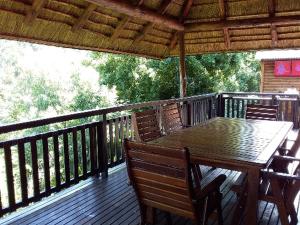 a wooden deck with a wooden table and chairs at Crocriver Chalet Schoemanskloof in Schoemanskloof