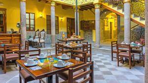 a restaurant with wooden tables and wooden chairs at Hotel La Basílica Quito in Quito