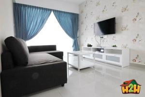 a living room with a chair and a television at H2H - Eleven14 Majestic Ipoh in Ipoh