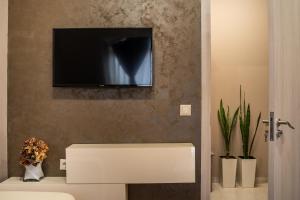 a bathroom with a tv on a wall with a toilet at Apartment Doyran in Ruse