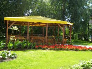 einen hölzernen Pavillon in einem Park mit Blumen in der Unterkunft Deims Hotel in Šilutė + 15 Fotos