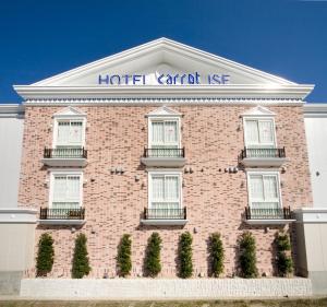 ein rotes Backsteingebäude mit einer Autovermietung des Hotels in der Unterkunft Carrot ISE (Adult Only) in Ise
