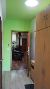 a room with green walls and a living room with a couch at Apartments U Kašny in Kadaň