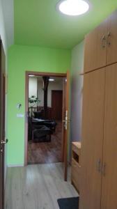 a room with green walls and a living room with a couch at Apartments U Kašny in Kadaň