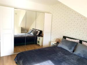 a bedroom with a bed and a mirrored wall at Malūno Vilos apartamentai in Palanga