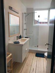 un bagno bianco con lavandino, vasca e finestra di Lola des Sources a Spa