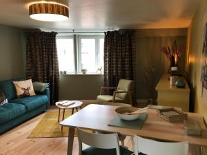 a living room with a table and a couch at Lola des Sources in Spa
