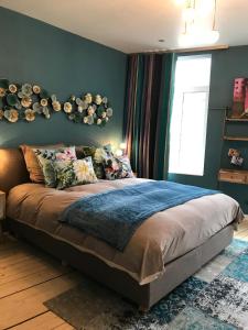 um quarto com uma cama grande e uma parede azul em Lola des Sources em Spa