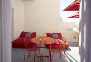 a room with a table and chairs and a couch at Art Hotel Santorini in Pirgos