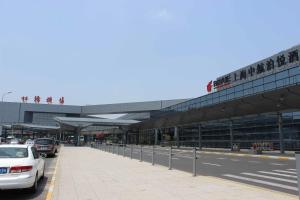 a parking lot with cars parked in front of a building at Shanghai Hongqiao Airport Hotel - Air China in Shanghai