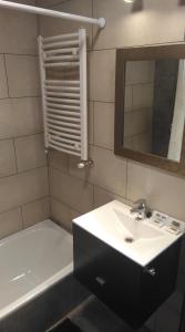 La salle de bains est pourvue d'un lavabo, d'un miroir et d'une baignoire. dans l'établissement Anita´s House, à El Chalten