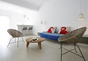 ピルゴスにあるArt Hotel Santoriniのベッド1台、椅子2脚、テーブルが備わる客室です。
