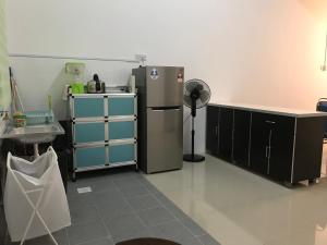 a kitchen with a refrigerator and cabinets and a sink at Tilapia Guest House Temerloh in Temerloh
