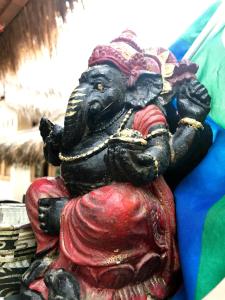 a statue of an elephant sitting on a red dress at Meno Madia Bungalows in Gili Meno