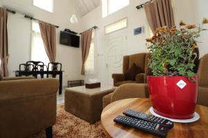 ein Wohnzimmer mit einem Tisch mit zwei Fernbedienung in der Unterkunft Diyar Villas Puncak R7-3 in Puncak