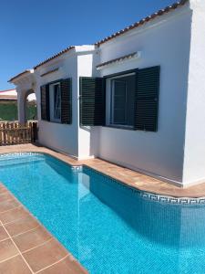 une villa avec une piscine en face d'une maison dans l'établissement Es Canto, à Cala Blanca