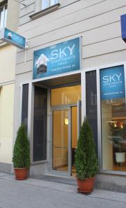 a building with two potted trees in front of it at Sky Apartments Vienna in Vienna