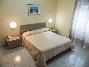 Hotel Desìo في كاستيلاماري دي ستابيا: غرفة نوم بها سرير وليلتين ومصبغتين