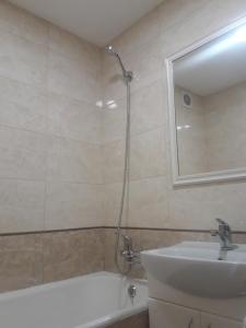 a bathroom with a sink and a tub and a mirror at Апартаменты Оболонь in Kyiv
