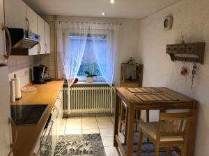 eine kleine Küche mit einem Tisch und einem Fenster in der Unterkunft Ferienhaus Nordseerobbe in Friedrichskoog